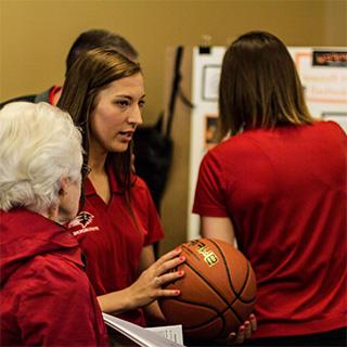 A student holds a basketball during a Discovery Day presentation